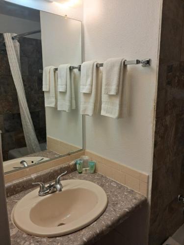 a bathroom with a sink and a mirror and towels at National 9 Inn Showboat in Casper