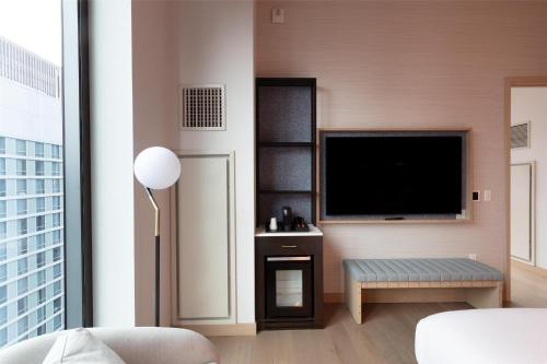 a living room with a flat screen tv and a couch at Tempo By Hilton New York Times Square in New York
