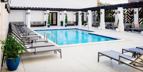 a pool with chaise lounge chairs and a hotel at The Chifley Houston, Tapestry Collection by Hilton in Houston
