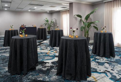 a row of tables in a room with plants at The Chifley Houston, Tapestry Collection by Hilton in Houston