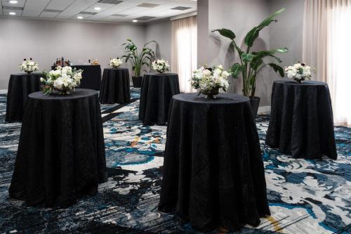 a row of tables in a room with flowers on them at The Chifley Houston, Tapestry Collection by Hilton in Houston