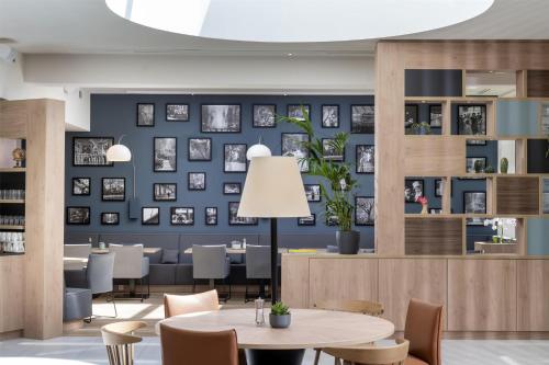 a dining room with blue walls and tables and chairs at Hampton By Hilton Potsdam Babelsberg in Potsdam