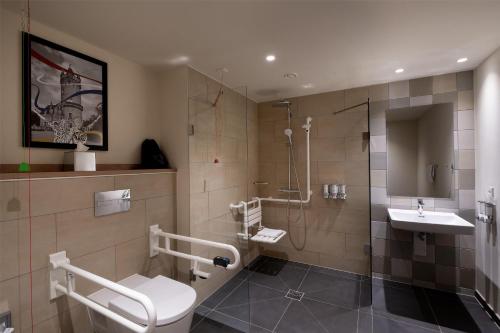 a bathroom with a shower and a toilet and a sink at Hampton By Hilton Potsdam Babelsberg in Potsdam