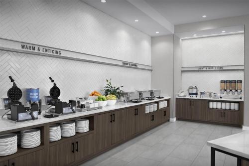 a restaurant with a counter with plates on it at Tru By Hilton Columbia Downtown in Columbia