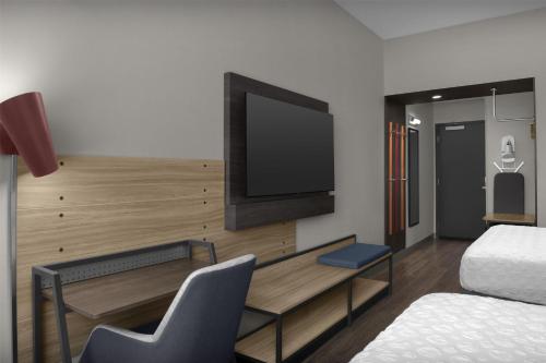 a room with a tv on a wall with a bed at Tru By Hilton Columbia Downtown in Columbia