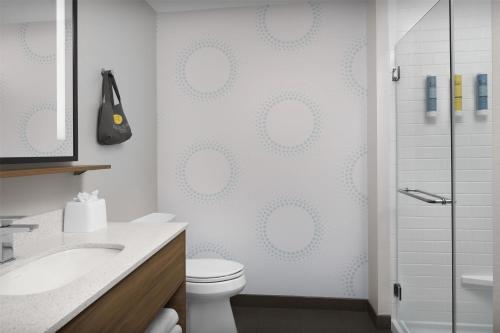 a white bathroom with a toilet and a shower at Tru By Hilton Columbia Downtown in Columbia