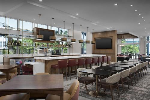 a restaurant with tables and chairs and a bar at Tru By Hilton Columbia Downtown in Columbia