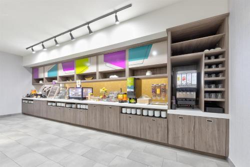 un restaurant de restauration rapide avec un comptoir aux fenêtres colorées dans l'établissement Home2 Suites By Hilton Paris, à Paris