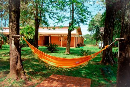 an orange hammock in front of a house at Encanto Rural in Bella Vista