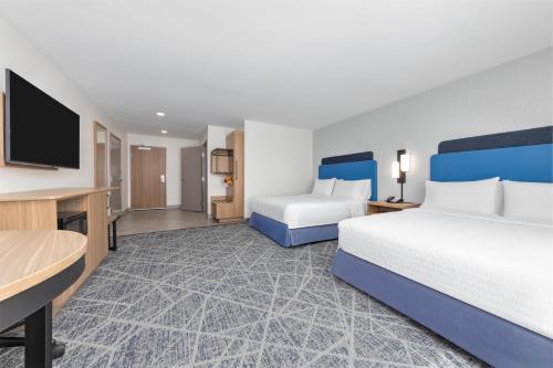 a hotel room with two beds and a flat screen tv at Hampton Inn & Suites by Hilton Little Rock Airport in Little Rock