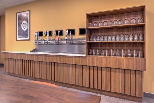 a lobby with a counter with cell phones on a shelf at Hampton Inn & Suites by Hilton Little Rock Airport in Little Rock