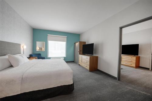 a hotel room with a bed and a television at Home2 Suites by Hilton Fort Walton Beach Eglin AirForce Base in Fort Walton Beach