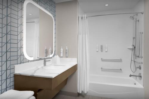a bathroom with a sink and a shower with a mirror at Homewood Suites By Hilton Columbia Downtown in Columbia