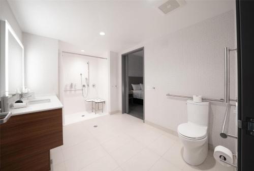 a white bathroom with a toilet and a sink at Home2 Suites by Hilton Fort Walton Beach Eglin AirForce Base in Fort Walton Beach