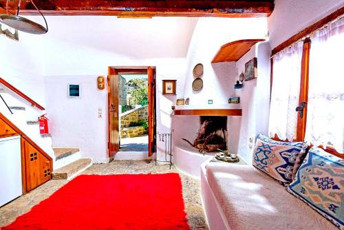 a living room with a couch and a red rug at Elounda Traditional Homes of Crete in Elounda
