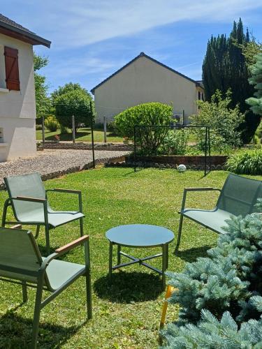 a group of chairs and a table in the grass at La maison des doux souvenirs in Les Riceys