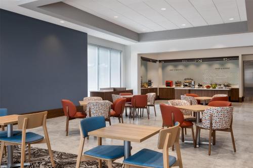 a waiting room with tables and chairs at Tru By Hilton Houston Downtown Convention Center in Houston