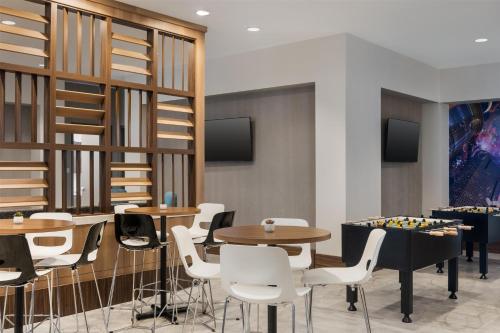 a dining room with tables and chairs and shelves at Tru By Hilton Houston Downtown Convention Center in Houston