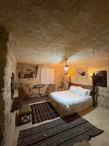 a bedroom with a bed and a desk in a room at İnaros Hotel in Mardin