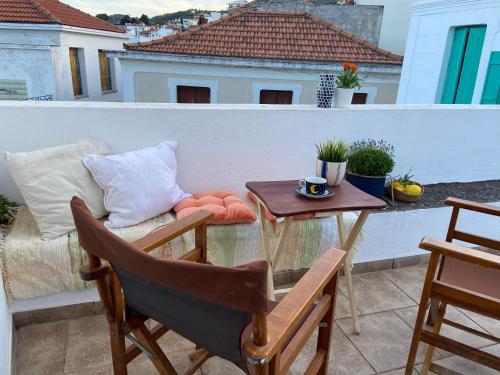 a balcony with a table and a chair and a table at Adele house in Skopelos Town
