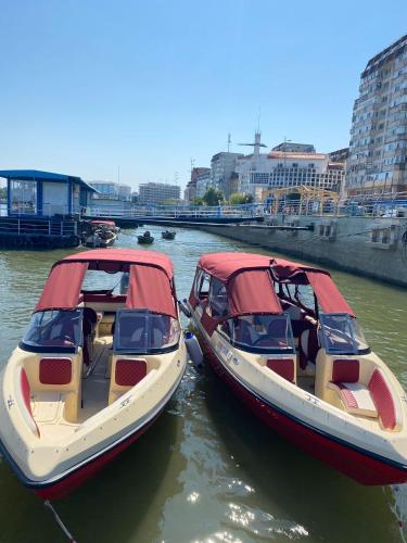 two boats are docked next to each other in the water at Pensiunea Bibanu in Mineri