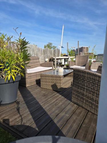 a patio with wicker chairs and a table on a deck at Atypique chambre sur péniche in Strasbourg
