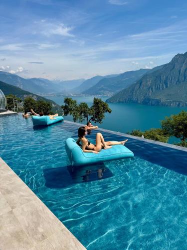 a group of people sitting on an inflatable raft in a swimming pool at Esprit D'Hotel Panoramico in Fonteno