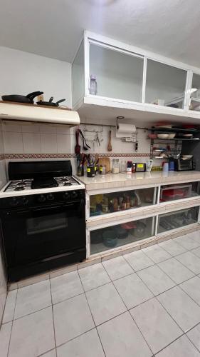 a kitchen with a stove and an open cabinet at Casamaya Hostel & Diving in Cozumel