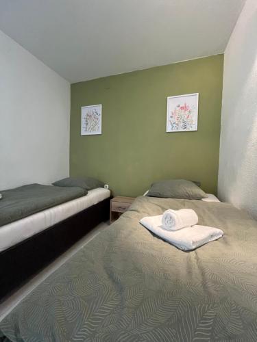 a bedroom with two beds with towels on them at Apartman Jugo in Kaštela