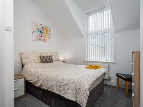 un dormitorio con una cama y una ventana en Apex Living NE - Beachville House II, en Sunderland