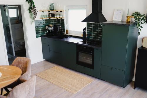 una cocina con armarios verdes y una mesa en Sohana House Rust I Lifestyle Apartments, en Rust