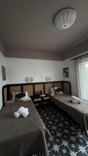 a bedroom with two beds and a large window at Levanta apartment in Asprovalta