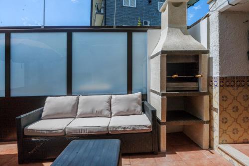 a couch sitting on a balcony with a fireplace at CASAL ESPINCHO - Castelo de Paiva, São Martinho de Sardoura in Castelo de Paiva