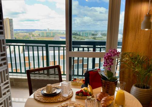 a table with food and a view of a balcony at Flat Premium - Capital Brasília Flats in Brasilia