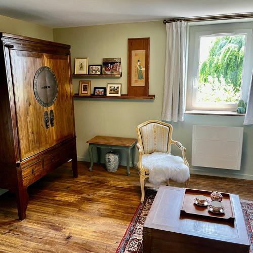 un salon avec une chaise et une table dans l'établissement La Maison de la Hulotte, à Golleville