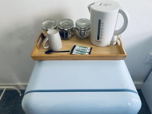 a wooden shelf with a coffee maker and jars on it at Igloo Magnolia Room Stay I Breakfast I Free Parking in Leeds