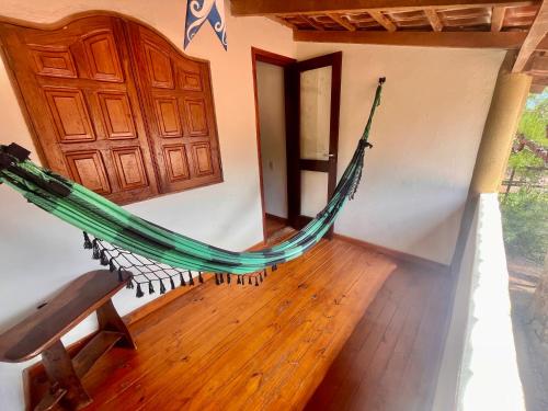 a hammock hanging in a room with a door at Espaço Shanti - Chalés in Sao Jorge