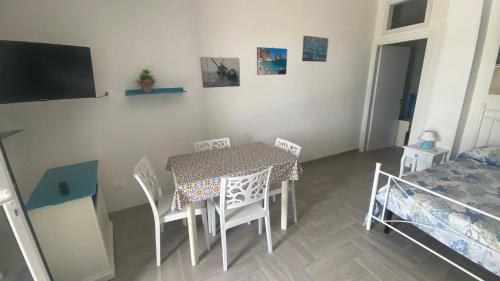 a dining room with a table and chairs and a bed at Casa Vacanze-Le stanze di Eolo in Marsala