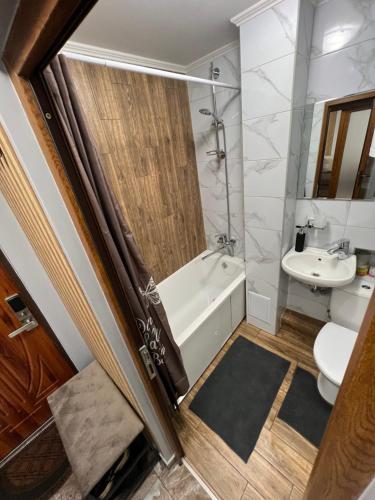 a bathroom with a tub and a toilet and a sink at Однокімнатна квартира in Chernivtsi