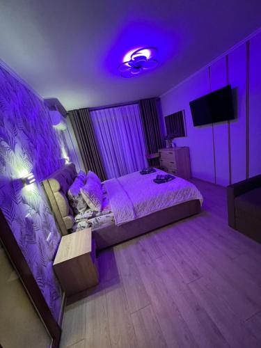 a purple room with a bed and a purple light at Однокімнатна квартира in Chernivtsi