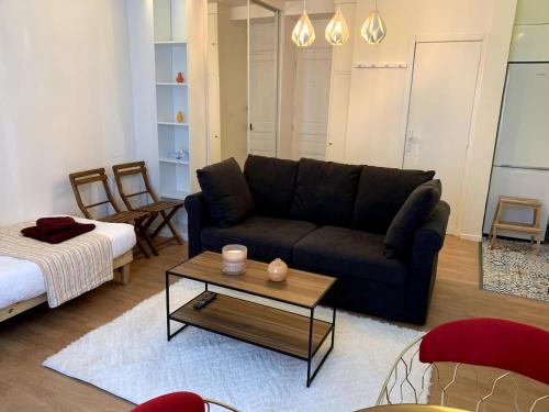 a living room with a couch and a coffee table at Appartement Confort - Puteaux La Défense in Puteaux