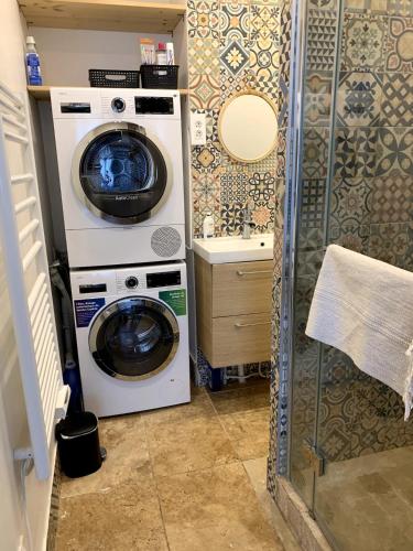 - un lave-linge et un sèche-linge dans une petite salle de bains dans l'établissement Appartement Confort - Puteaux La Défense, à Puteaux