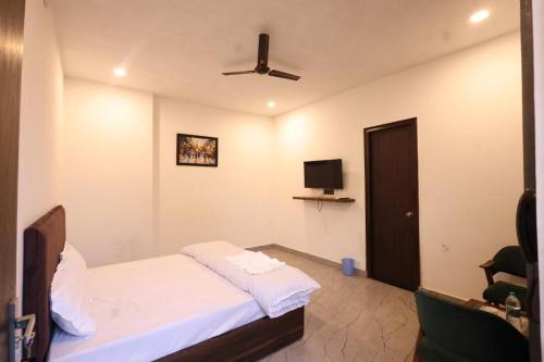 a hotel room with a bed and a tv at The Lagoon in Samālkha
