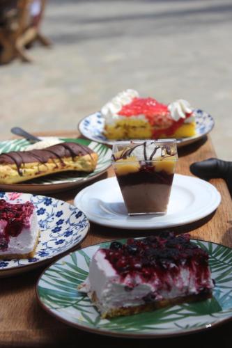 a group of desserts on plates on a wooden table at Bujtina Ajazi in Golem