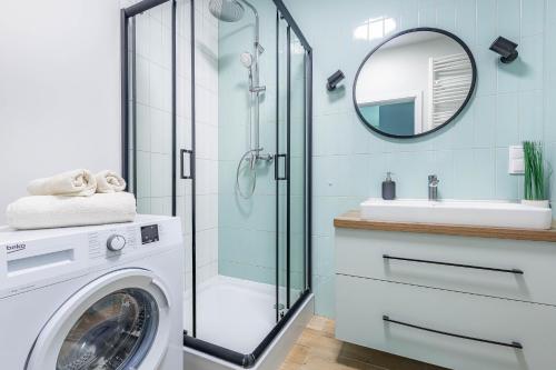 a washing machine in a bathroom with a mirror at Apartament Wilanow in Warsaw