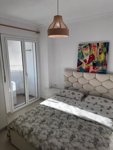 a bedroom with a bed and a large window at Apartment near Lungo Mare beach in Vlorë