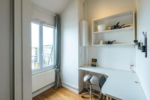 Cette chambre dispose d'un bureau et d'une fenêtre. dans l'établissement Charming Studio - Eiffel Tower, à Paris