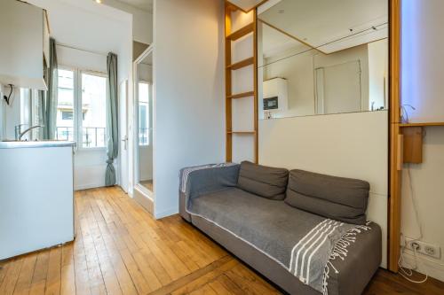 un salon avec un canapé et un miroir dans l'établissement Charming Studio - Eiffel Tower, à Paris