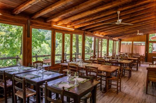 a dining room with tables and chairs and windows at Agriturismo La Ferrera in Varco Sabino