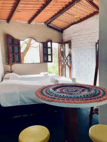 a bedroom with a bed and two stools at Espaço Shanti - Chalés in Sao Jorge